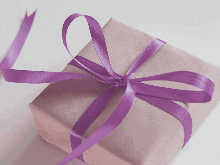 Elegant pink gift box wrapped with a purple satin ribbon, ideal for special occasions or corporate gifts.