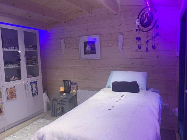Soft purple mood lighting in bedroom with dreamcatcher and spiritual decor, creating a calming ambiance.