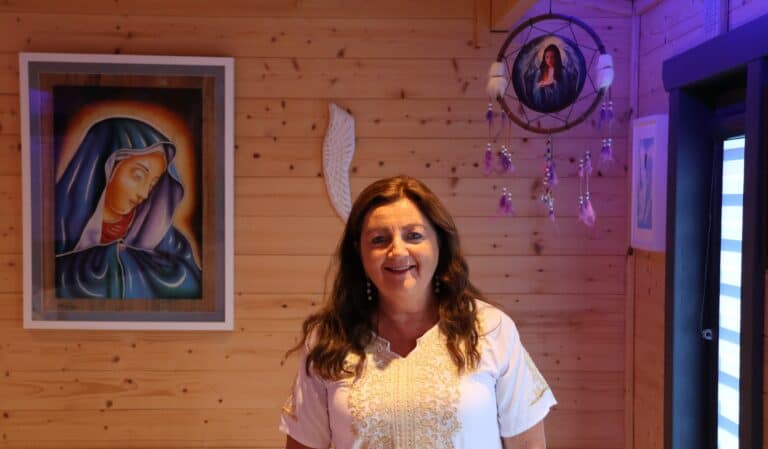 Soft warm lighting illuminating a woman in a cozy wooden interior, creating a welcoming ambiance.