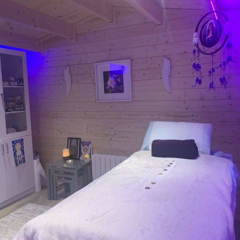 Soft purple mood lighting in bedroom with dreamcatcher and spiritual decor, creating a calming ambiance.