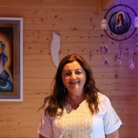 Soft warm lighting illuminating a woman in a cozy wooden interior, creating a welcoming ambiance.